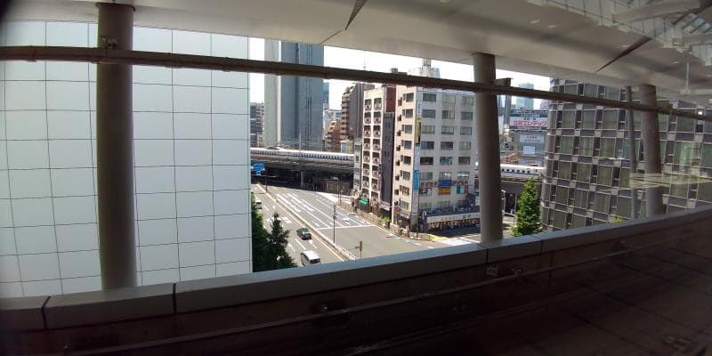 高い駅から新幹線が遠くを走るのを眺める